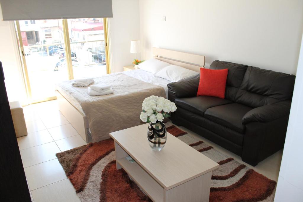 拉纳卡蒂芙尼城市公寓式酒店的客厅配有沙发和桌子
