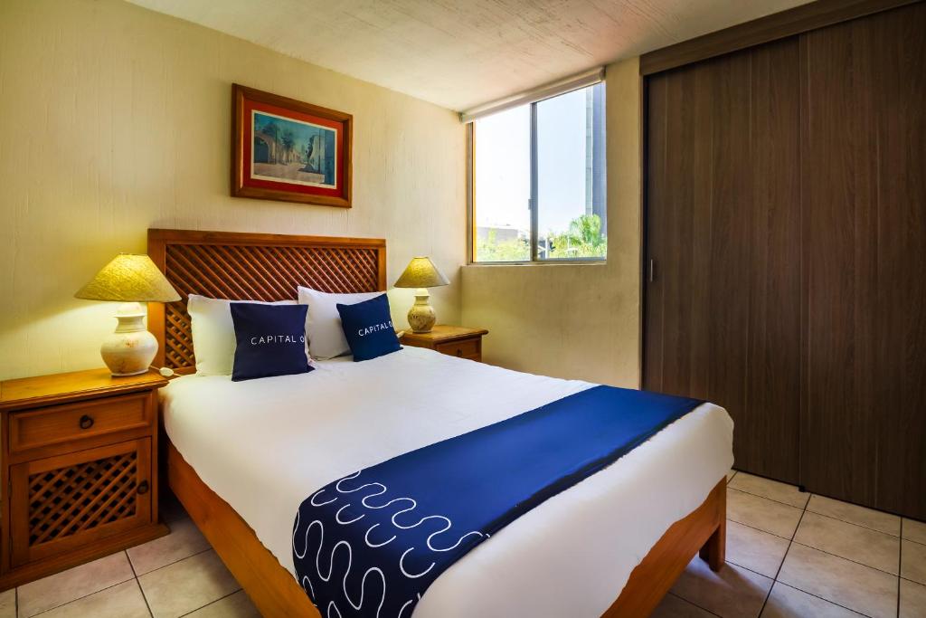 瓜达拉哈拉Suites Navata的一间卧室设有一张大床和一个窗户。