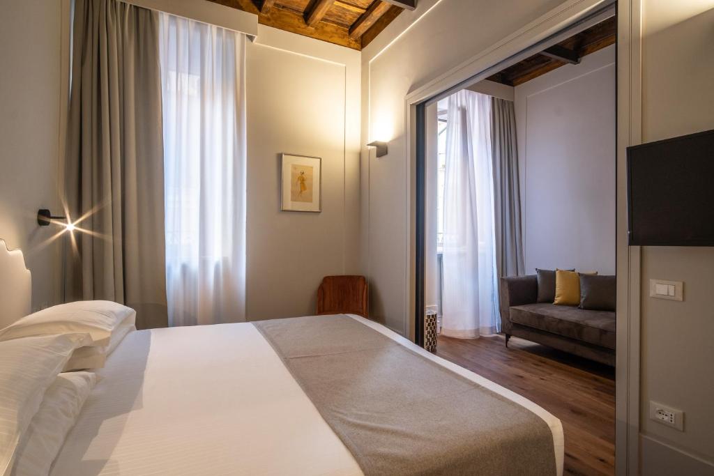 罗马Smeraldo Townhouse的卧室配有一张白色的大床和一张沙发。