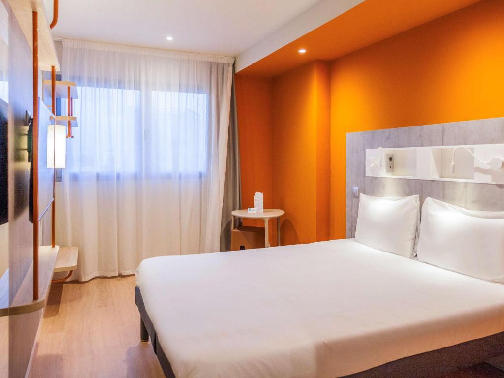 穆尔西亚ibis budget Huerta De Murcia的卧室设有一张白色大床和一扇窗户。