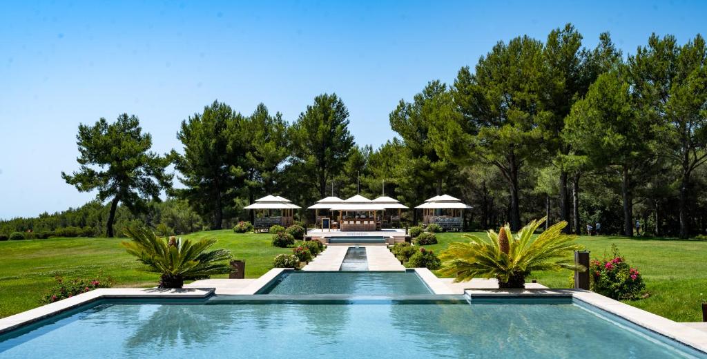 勒卡斯特雷特卡斯特雷特酒店及Spa的树木繁茂的庭院中的一个游泳池