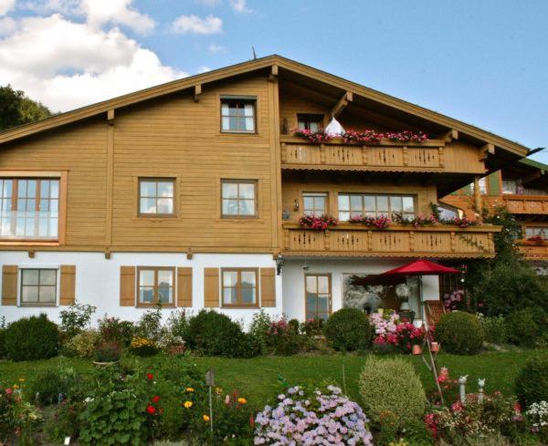萨默贝格Landhaus Binder的带阳台和鲜花的大型木屋