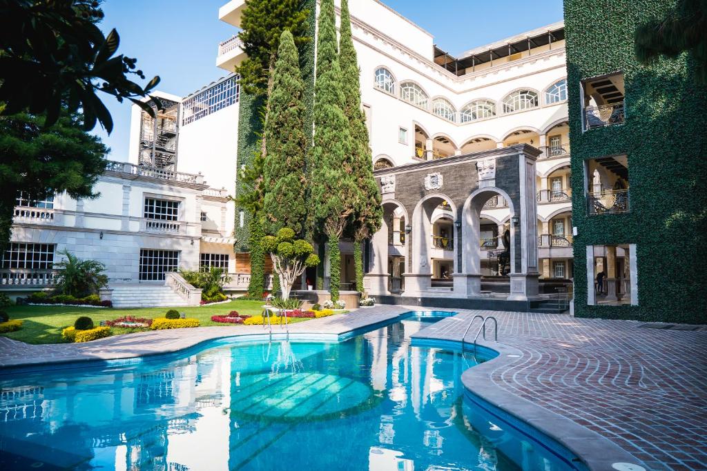 莫雷利亚HOTEL & SPA MANSION SOLIS by HOTSSON的一座建筑的庭院中的游泳池