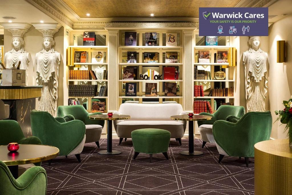 布鲁塞尔沃里克百赛酒店的一间设有绿色椅子和桌子的等候室
