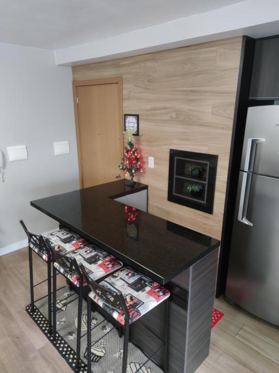 本图贡萨尔维斯Apartamento no Residencial Vert em Bento Gonçalves-RS的厨房配有黑色柜台和冰箱。