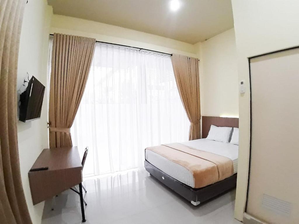 PaalmerahRedDoorz Syariah near Transmart Jambi 2的一间卧室设有一张床和一个大窗户