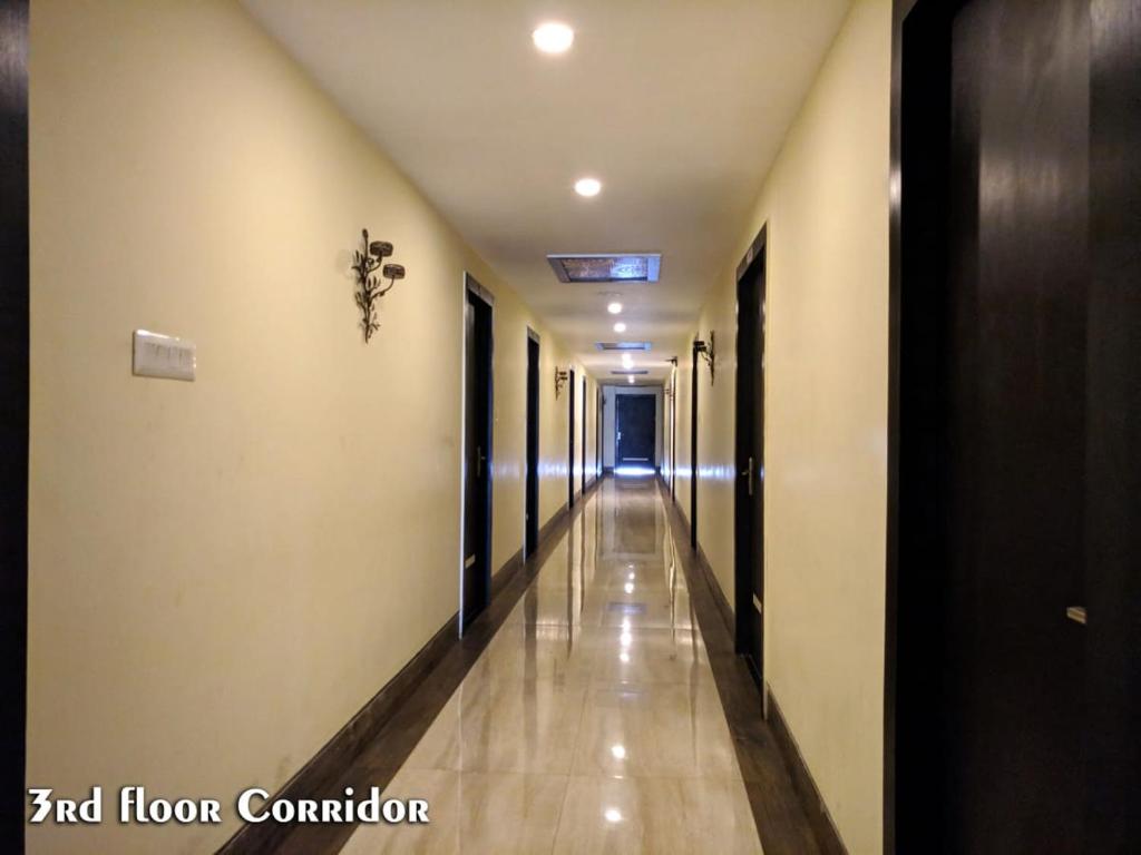 丹巴德Hotel Madhuvan by TravelkartOnline的走廊上设有长长的走廊,走廊上设有门和地板