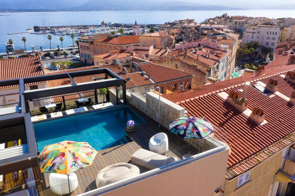 阿雅克修Hôtel Fesch & Spa的一座带遮阳伞的建筑屋顶上的游泳池