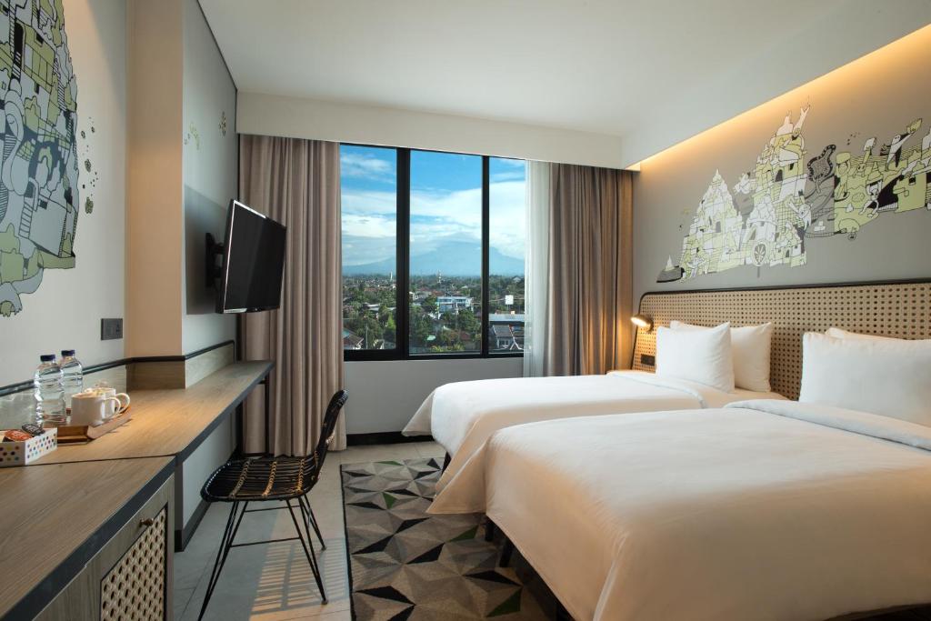 日惹ARTOTEL Yogyakarta的酒店客房设有两张床和电视。