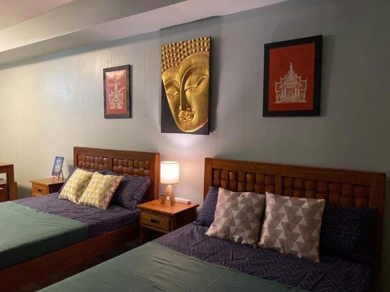 大雅台Wind and Sea at Wind Residences的卧室配有两张床,墙上设有金色的头