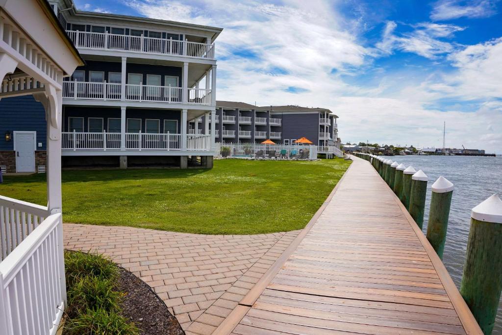 钦科蒂格Comfort Suites Chincoteague Island Bayfront Resort的水体旁有走道的建筑物