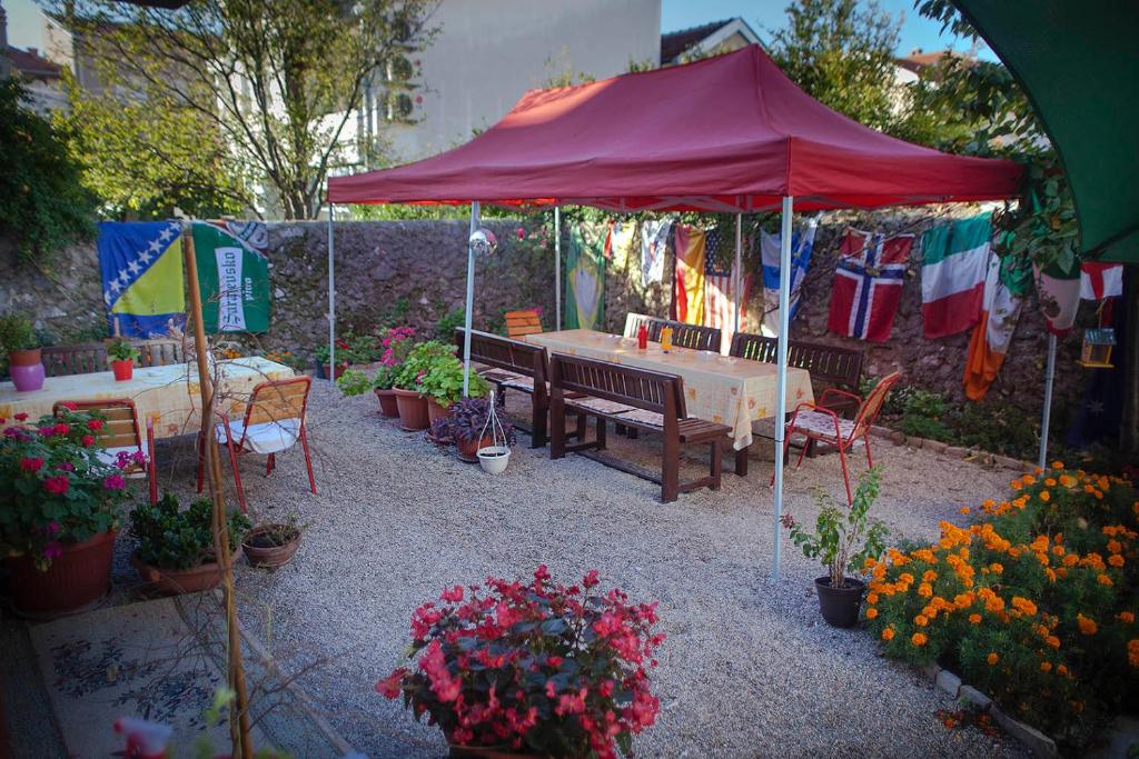 莫斯塔尔Majdas的花园中红色遮阳伞下的野餐桌