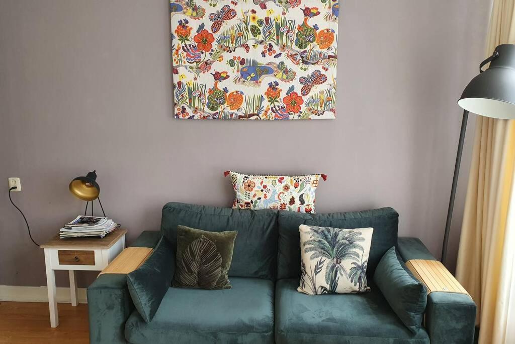 阿姆斯特丹Charming apartment in city center的客厅里一张绿色的沙发,墙上挂着一幅画
