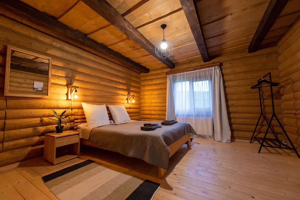 HuklyvyyChalet Borzhava的木制客房内的一间卧室,配有一张床