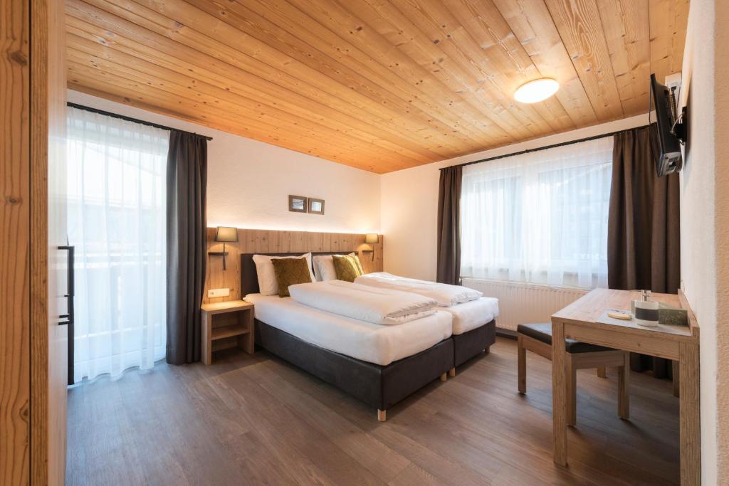 圣安东阿尔贝格Chalet Rosanna的酒店客房配有一张床铺和一张桌子。