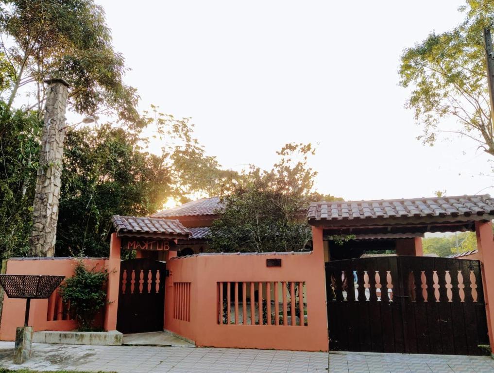佩鲁伊比Pousada Maktüb的橙色的房子,设有门和栅栏
