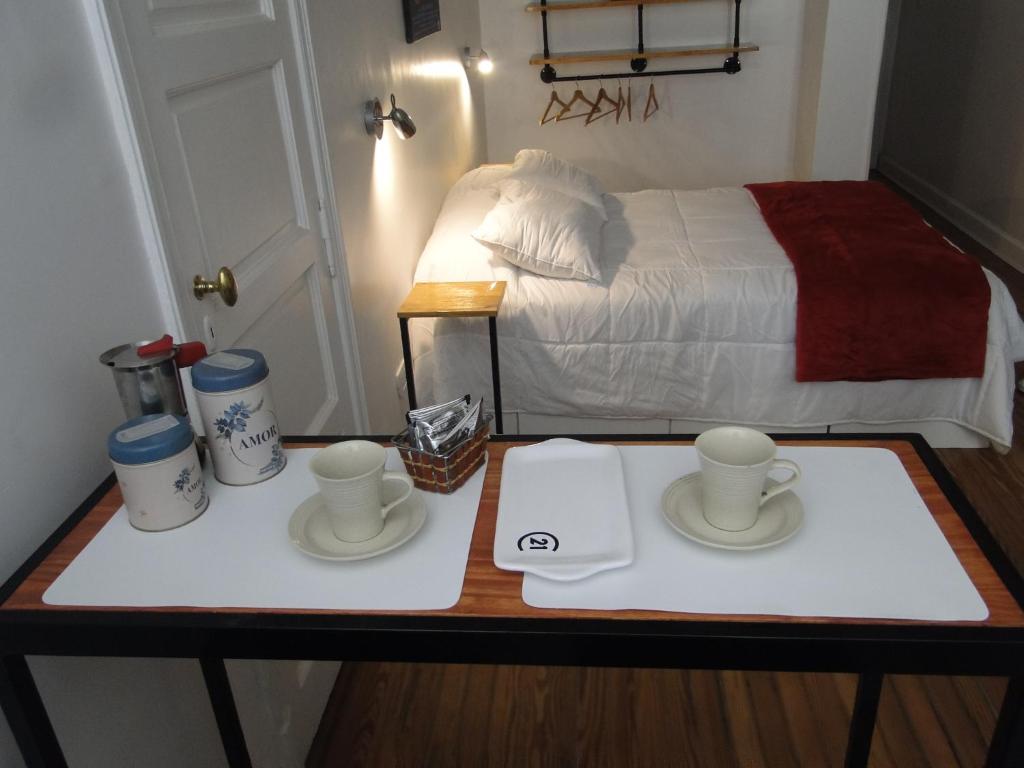 布宜诺斯艾利斯Lavalle Studio Buenos Aires的一张桌子,上面有两杯,盘子,床