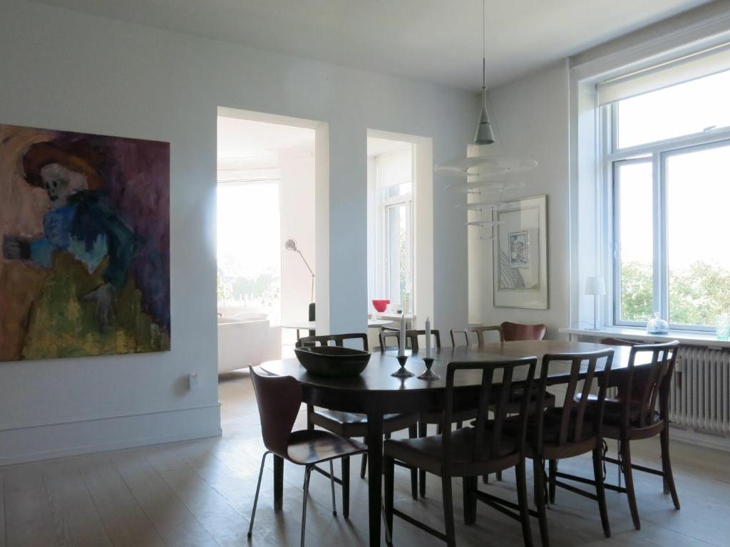 哥本哈根ApartmentInCopenhagen Apartment 1280的一间带桌椅和绘画的用餐室