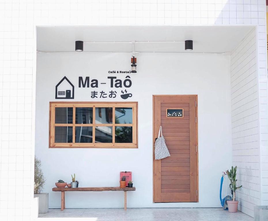 南府Ma-TaÔ またお Café & hostel的带有门和读取图标的建筑物
