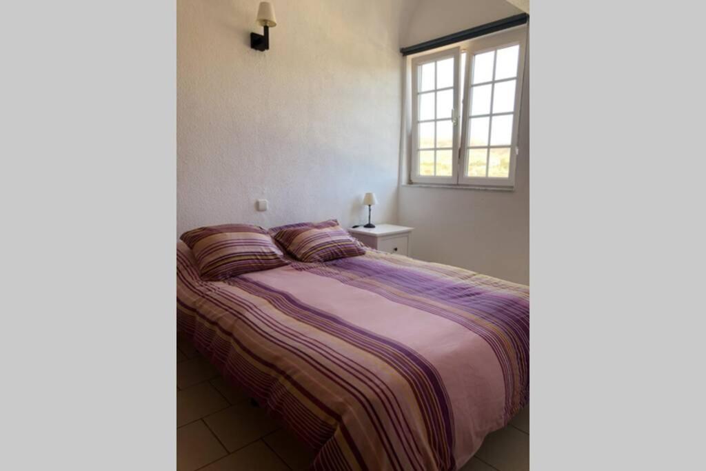 PájaraApartamento en La Pared Fuerteventura vista mar的窗户和床罩的房间里一张床位