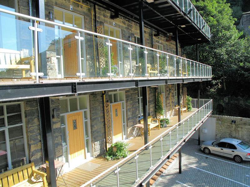 海伯敦桥克罗夫特米尔酒店的一座设有黄色门和汽车阳台的建筑