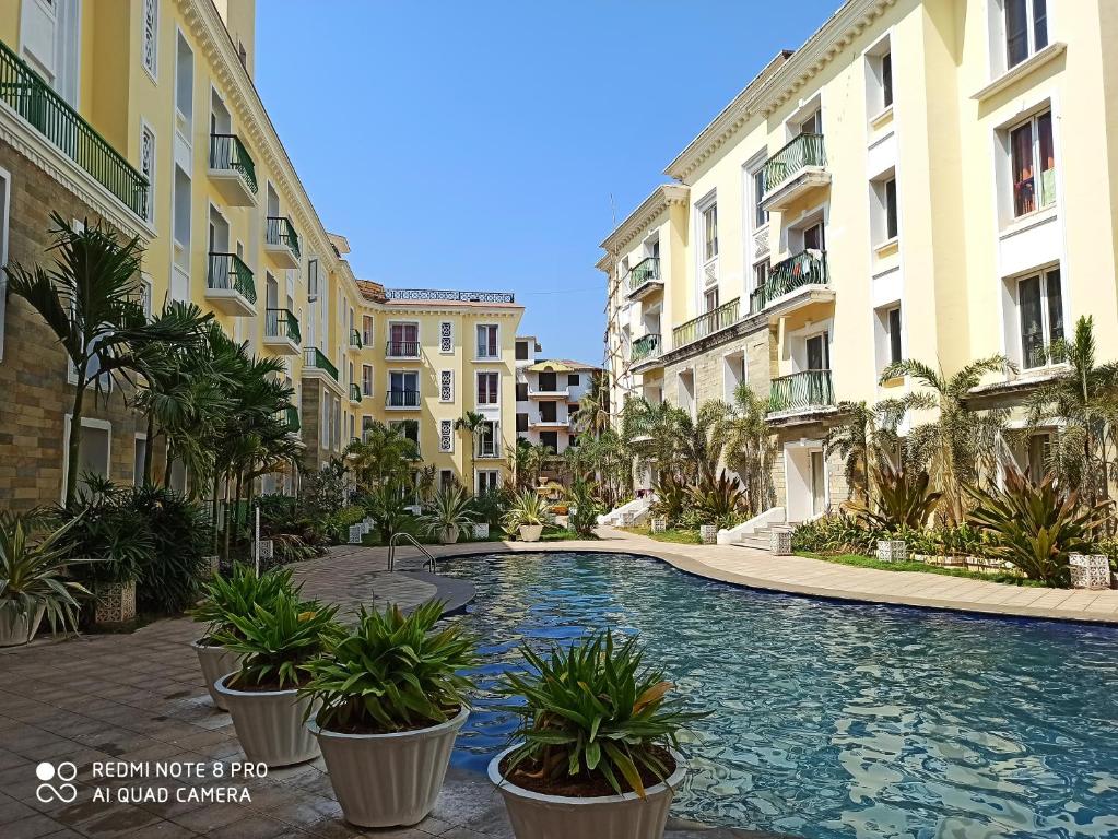 阿伯来Areia De Goa Luxury Condo的一座游泳池,位于部分建筑的中间