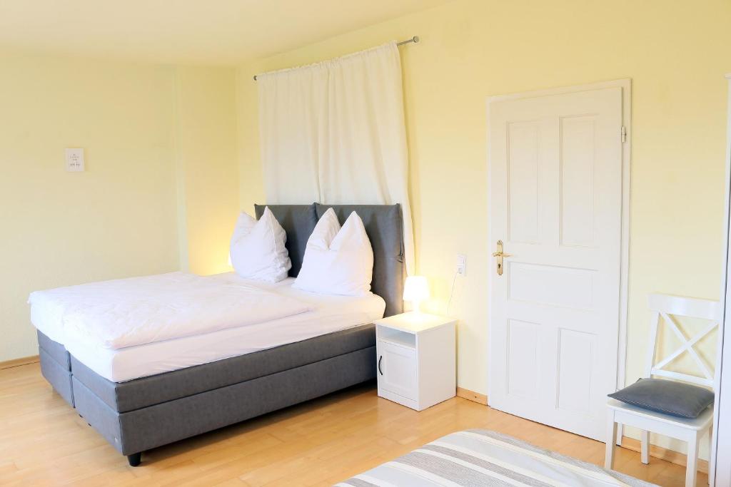 贝尔吉施格拉德巴赫Ferienwohnungen Domblick-Herkenrath的一间卧室配有带白色床单和枕头的床。