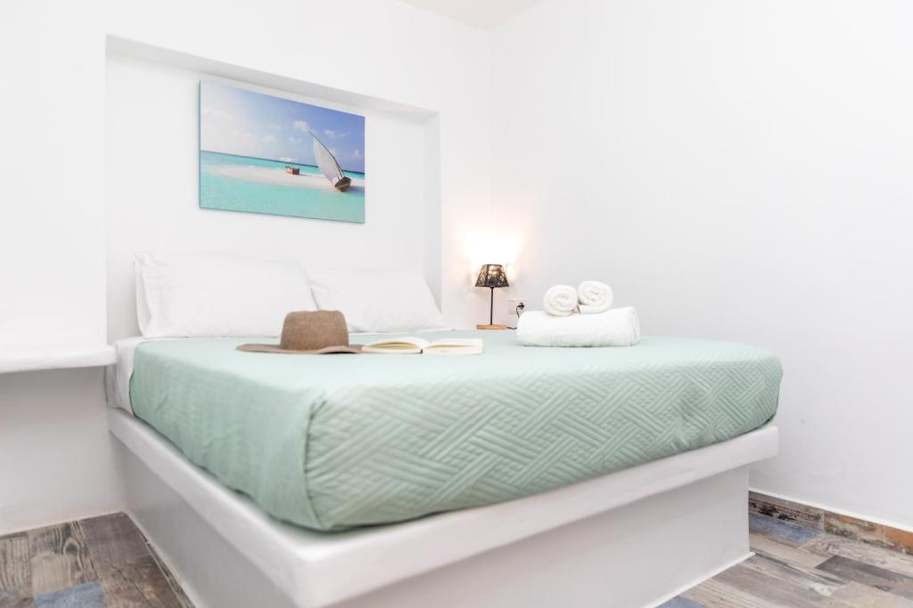 纳克索乔拉Depis Luxury Suites的白色卧室配有带绿色床单的床