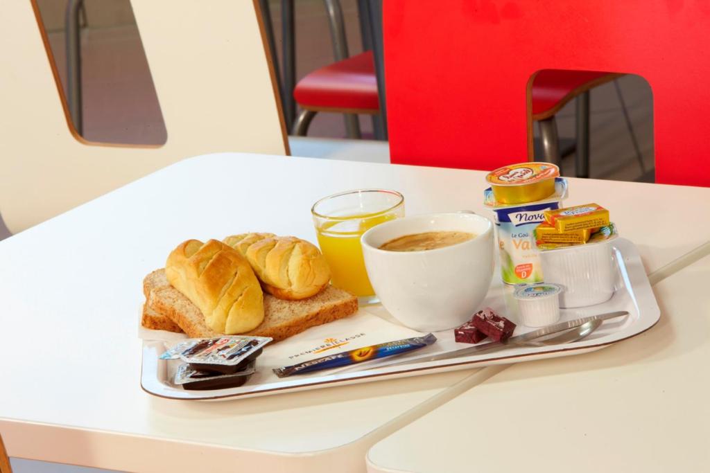 勒梅尼尔阿姆洛普瑞米尔鲁瓦西勒梅阿姆洛酒店的桌上的早餐食品和咖啡托盘