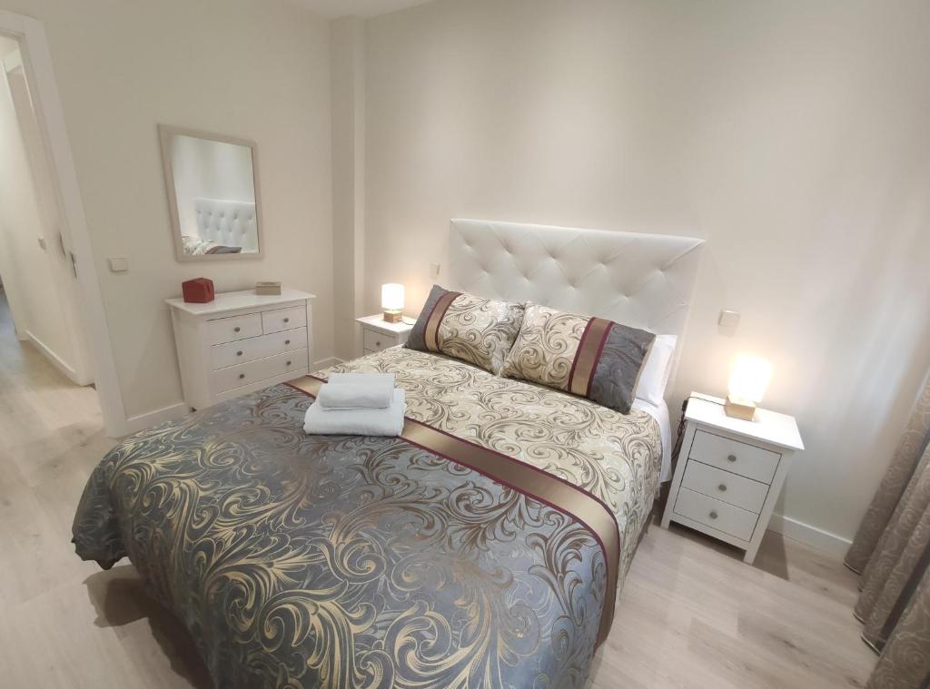 托莱多Apartamento Rosa Park的一间卧室设有一张大床和两个床头柜