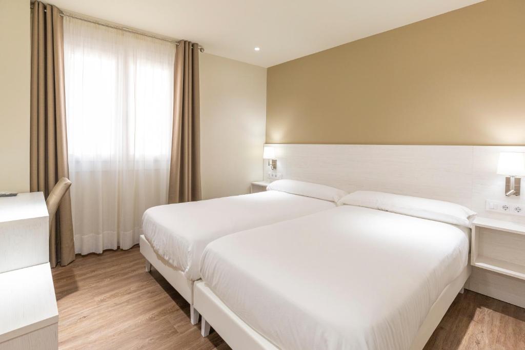 米尼奥Hotel La Terraza的卧室设有一张白色大床和一扇窗户。