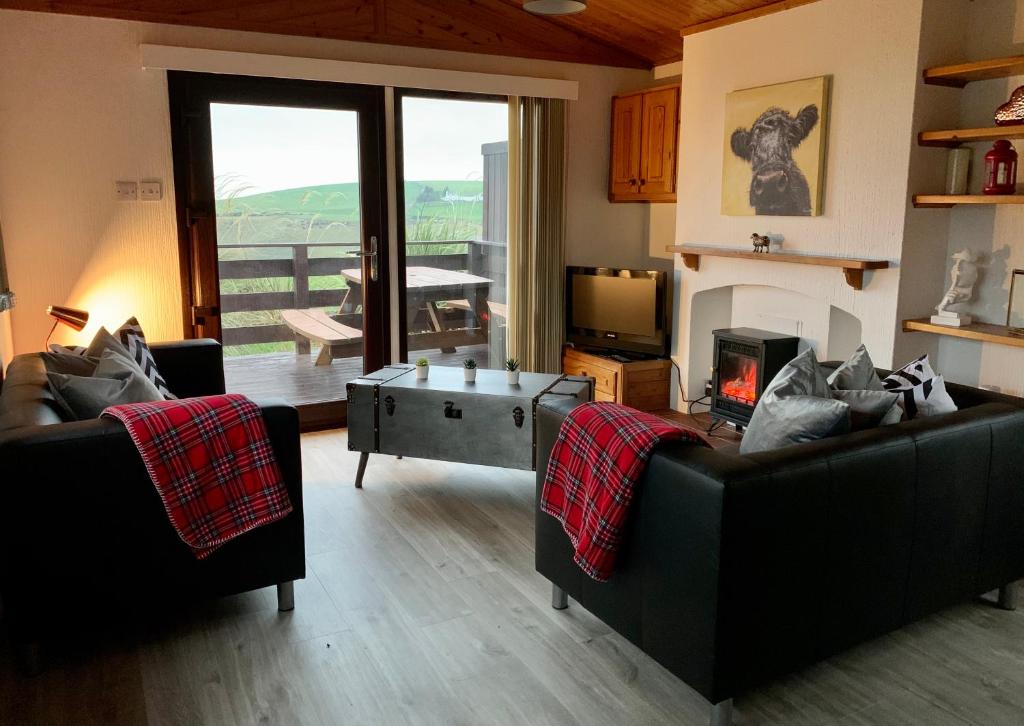 斯特兰拉尔Lodge Cabin with Fabulous Views - Farm Holiday的客厅配有两张沙发和一张咖啡桌