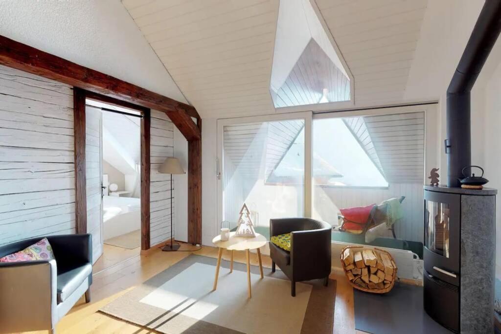 沙尔梅Charmant et lumineux appartement Duplex à Charmey的客厅设有拱形天花板和大窗户。
