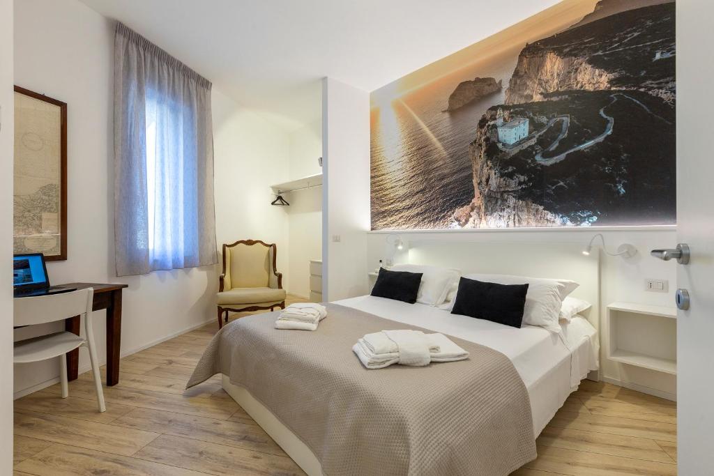 阿尔盖罗RelaisApartments MERCEDE - Extraordinary Hospitality的一间卧室配有一张床、一张桌子和一台电脑