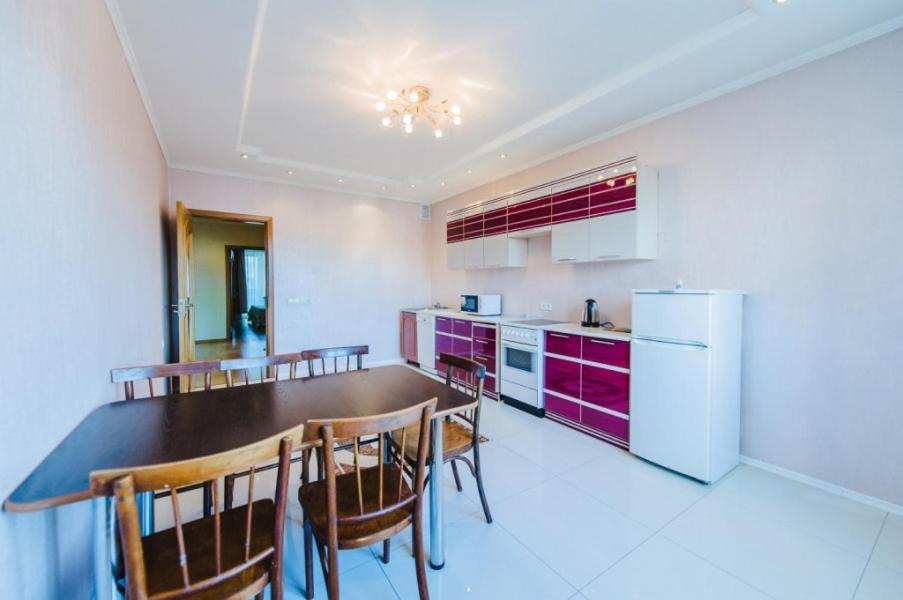赤塔Dekabrist Apartment at anokhina 93的厨房配有桌椅和冰箱。