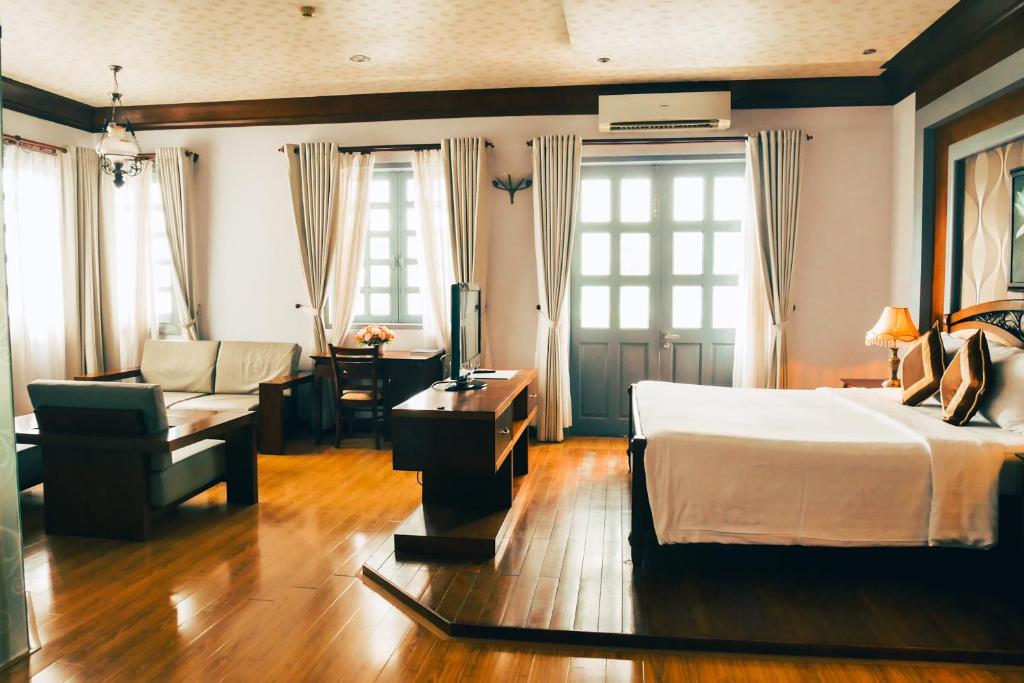 芽庄Rembrandt Hotel Nha Trang的一间卧室设有一张床和一间客厅。