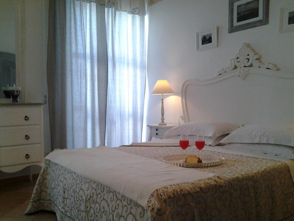 莫诺波利旧门住宿加早餐旅馆的一间卧室配有一张带两杯葡萄酒的床