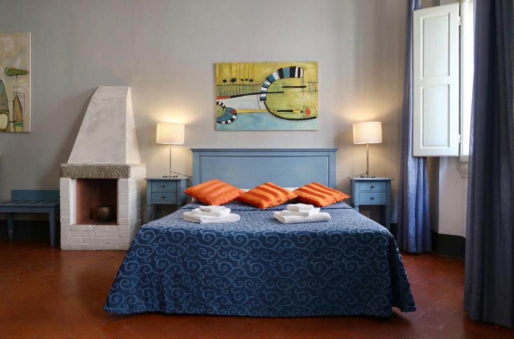 佛罗伦萨洛k安达德拉乐美酒店的一间卧室配有蓝色的床和橙色枕头