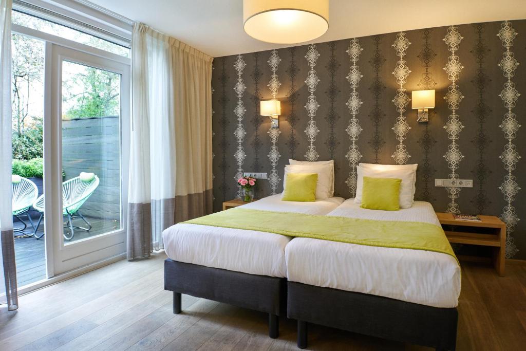 阿姆斯特尔芬阿尔普维内酒店的一间带大床的卧室和一个阳台