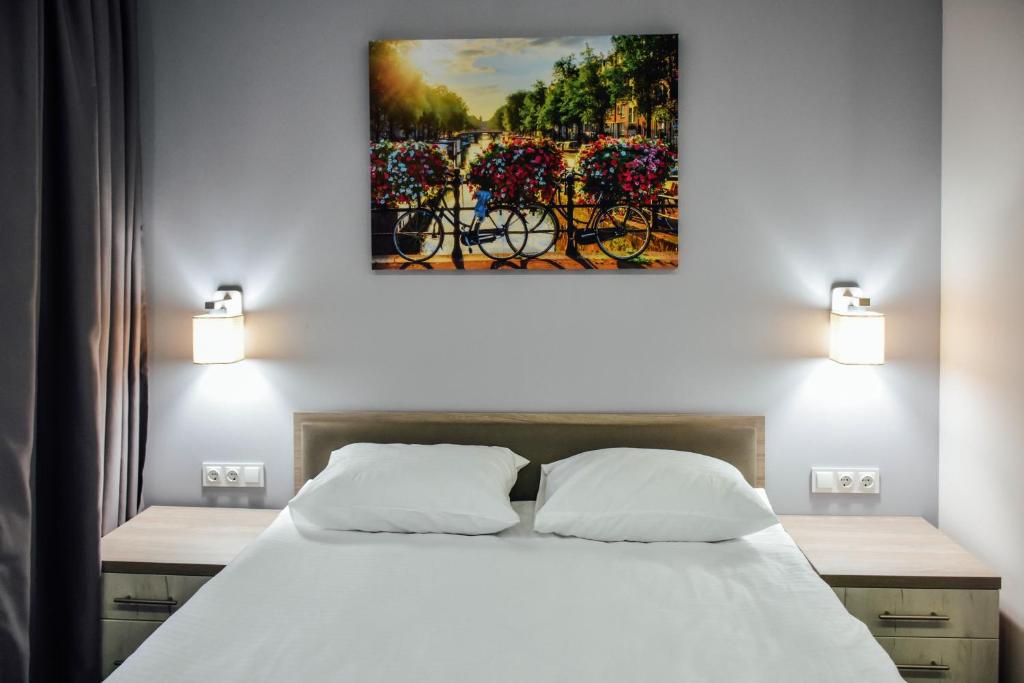 NizhynPark Hotel的卧室配有一张床,墙上挂有绘画作品