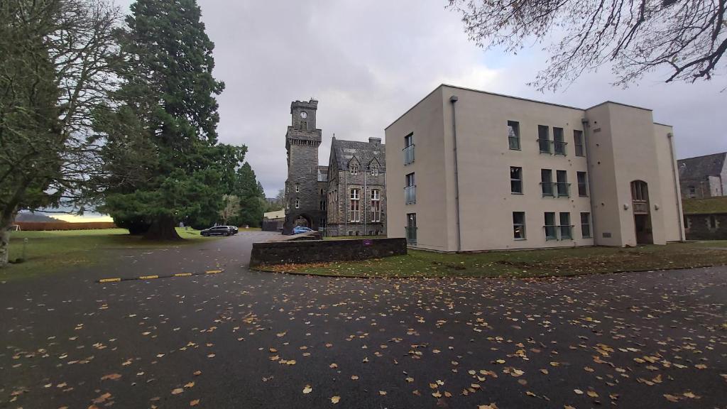 奥古斯都堡Raven Wing Apartments - Highland Club Scotland的一座古老的建筑,前面有一座塔