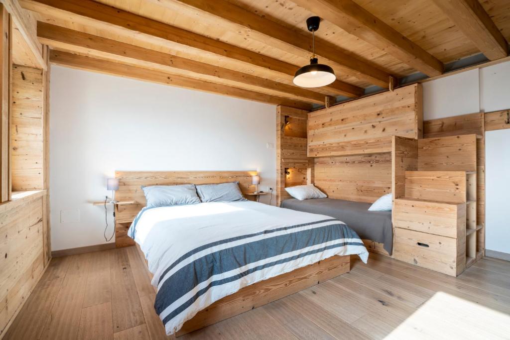 RotzoCasa Ekharle - Affittacamere的一间卧室设有一张大床和木墙