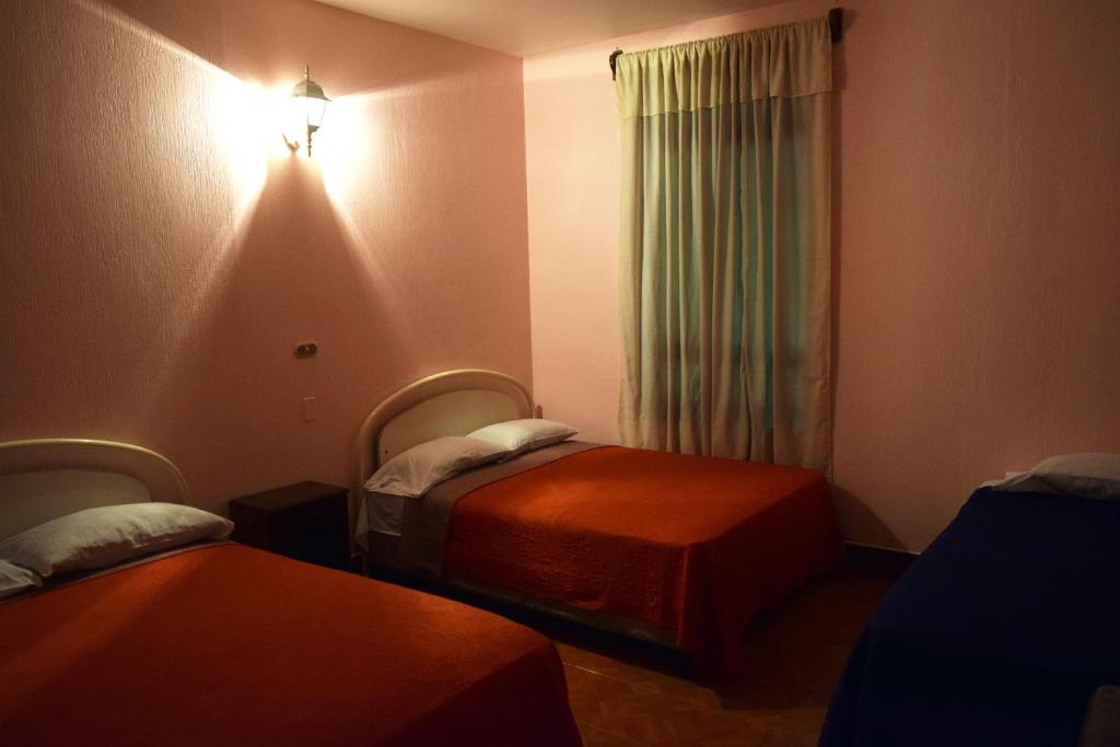 危地马拉Hotel Posada del Centro的酒店客房设有两张床和窗户。