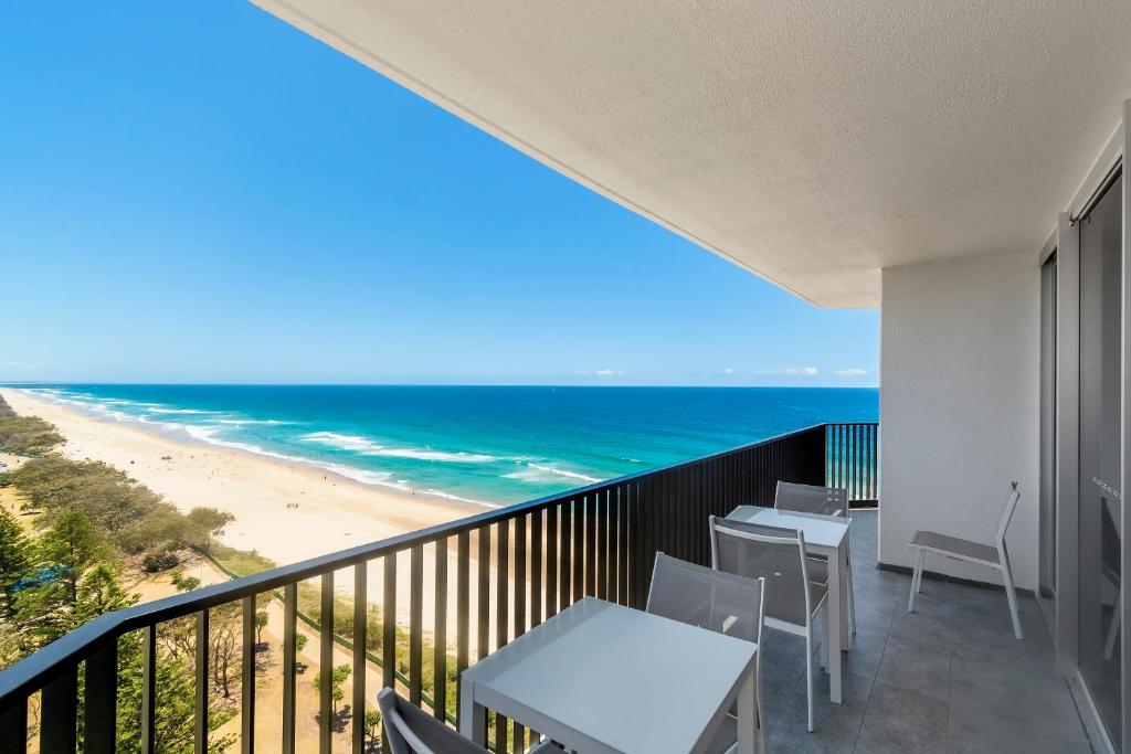 黄金海岸Golden Sands on the Beach - Absolute Beachfront Apartments的一个带桌椅的阳台和海滩