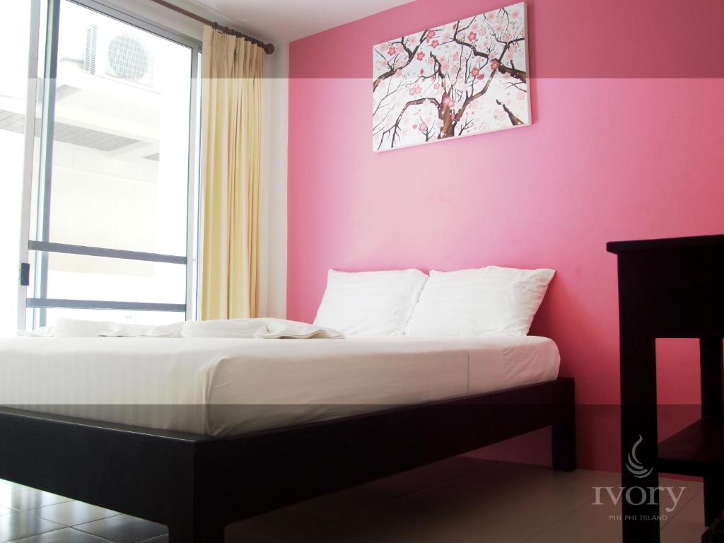 皮皮岛皮皮岛象牙酒店的粉红色墙壁的房间里一张床位