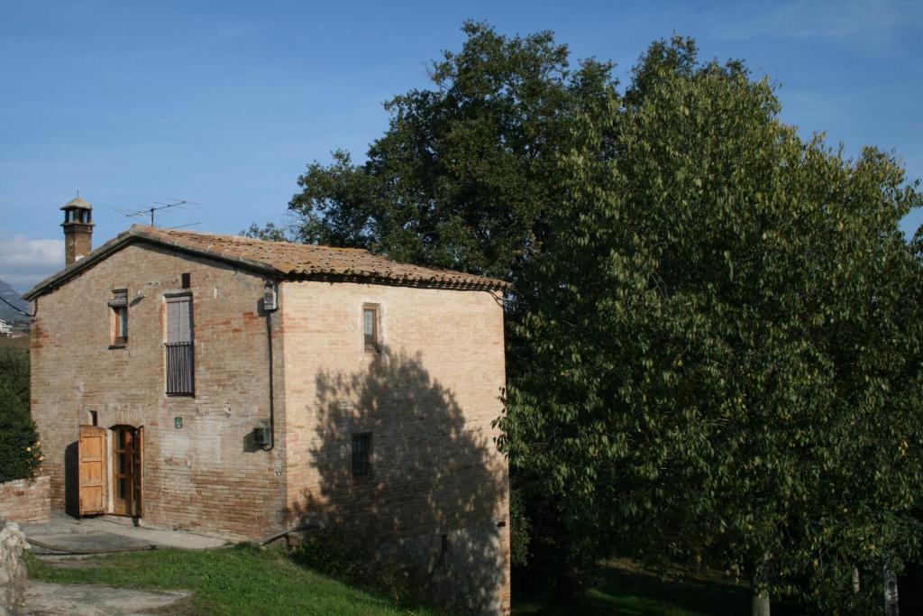 希罗内利亚卡尔西斯特勒度假屋的一座古老的砖砌建筑,旁边是树
