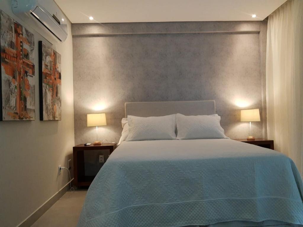 皮帕FLAT NA PRINCIPAL DE PIPA的一间卧室配有一张大床,桌子上放着两盏灯