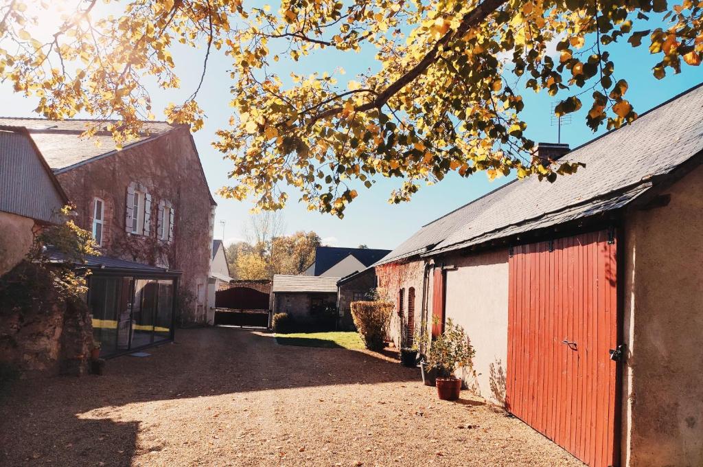 Saint-Aubin-de-LuignéL'Aubinoise的一座谷仓,在建筑物旁边设有红色的门