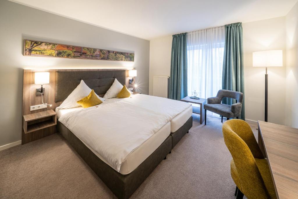 弗雷登Hotel Meyerink的酒店客房设有一张大床和一张书桌。