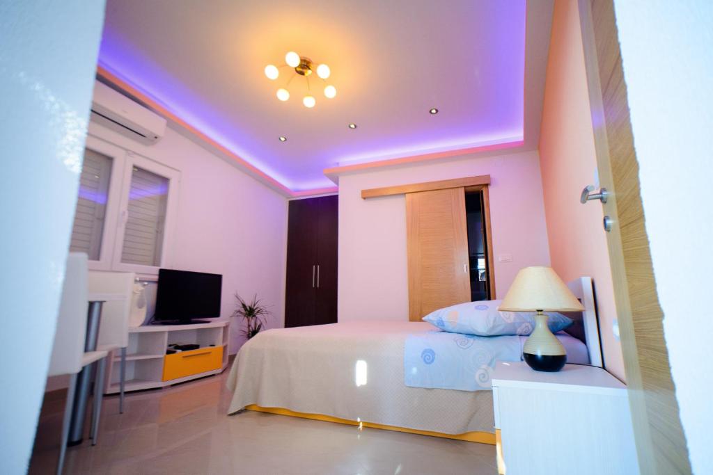 马卡尔斯卡劳拉公寓的一间卧室配有一张紫色天花板的床